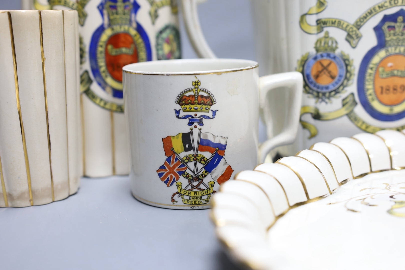 National Rifle Association Wimbledon 1889 - A group of Staffordshire commemorative pottery, including two water jugs, 18 cm high, and three matching beakers, a teapot and cover, a tray, together with a WW1 mug